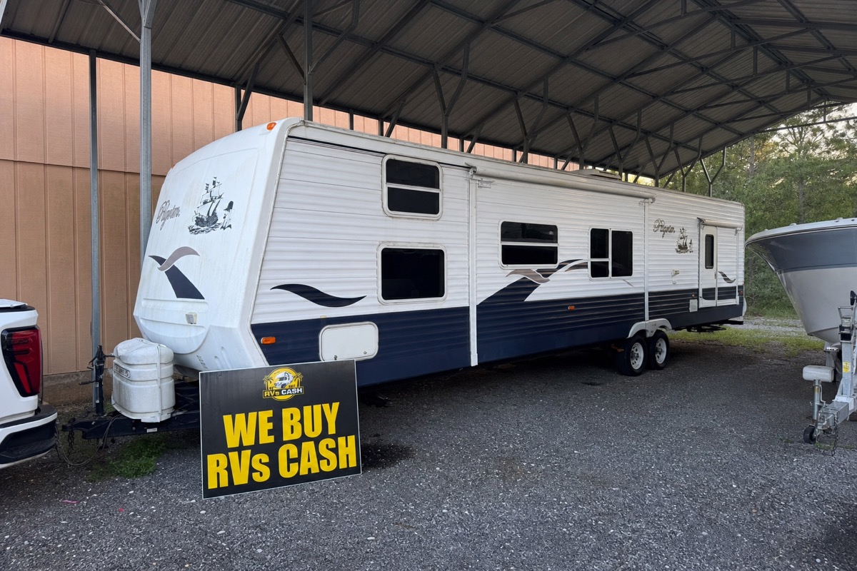 Travel trailer under a metal carport, side profile — We Buy RVs Cash, Florida
