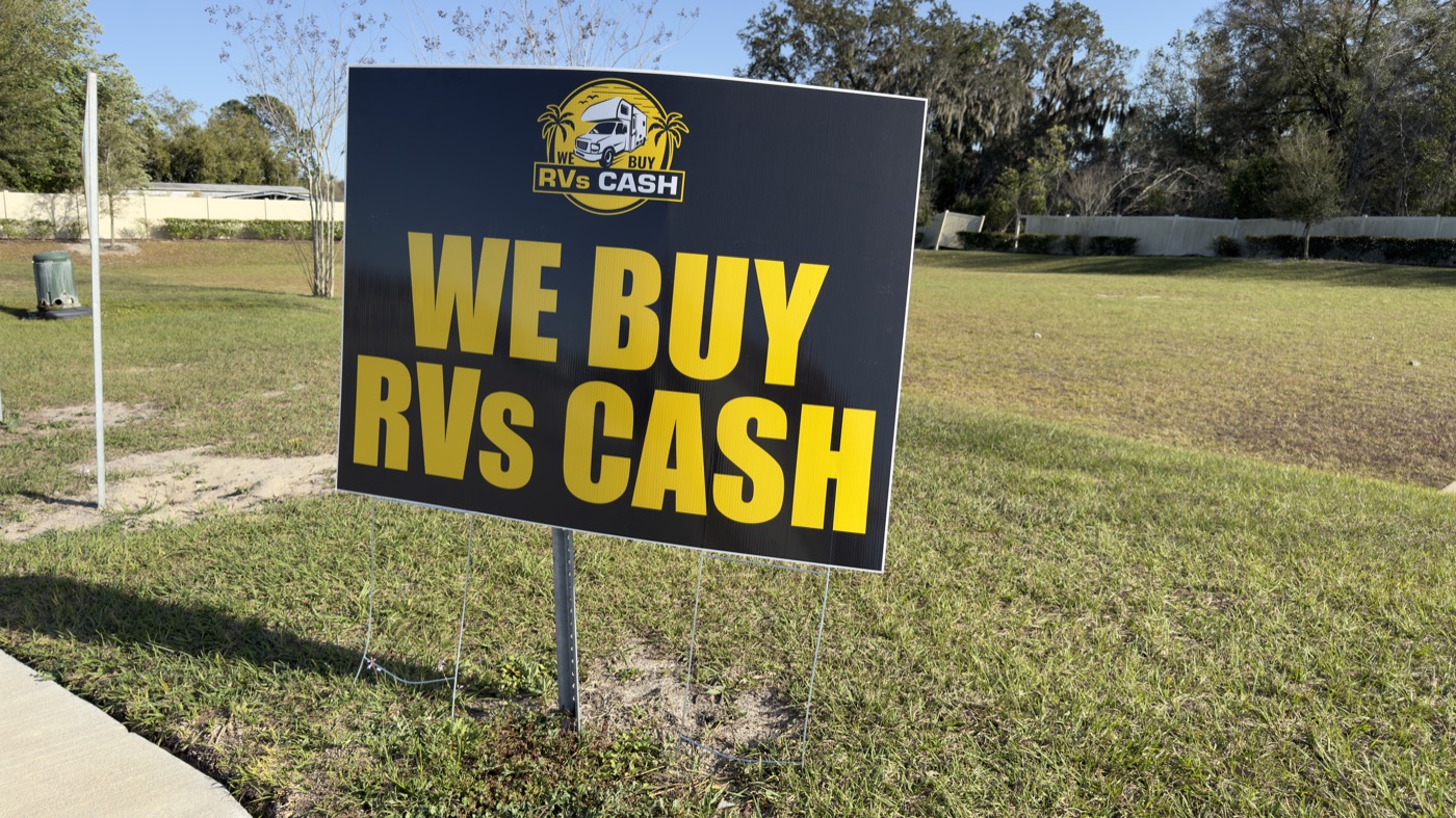 We Buy RVs Cash yard sign standing in a Florida front yard after a sale
